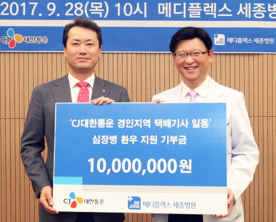 김태승 CJ대한통운 상무(왼쪽)와 박진식 혜원의료재단 이사장(오른쪽)이 ‘택배기사 희망의 한걸음’을 통해 조성된 치료금 전달식에서 기념 촬영을 하고 있다. (사진=CJ대한통운)