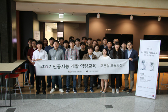 인공지능 개발 역량교육을 받고 있는 교육생들이 강의장 앞에서 기념촬영 하는 모습 (사진=KT)