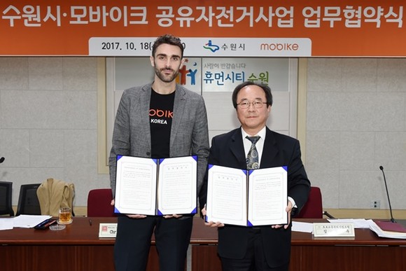 김철우 수원시 도로교통관리사업소장과 크리스 마틴 모바이크 부사장이 업무협약 후 기념 촬영을 하고 있다.(사진=수원시)