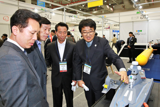 지난 3일 구미 구미코에서 개최된 '2017 국방 ICT 융합 산학관군 협력대전 및 정보화컨퍼런스'에 참가한 관계자들이 LIG넥스원 홍보부스에서 무인수상정에 대한 설명을 듣고 있다. (사진=LIG넥스원)