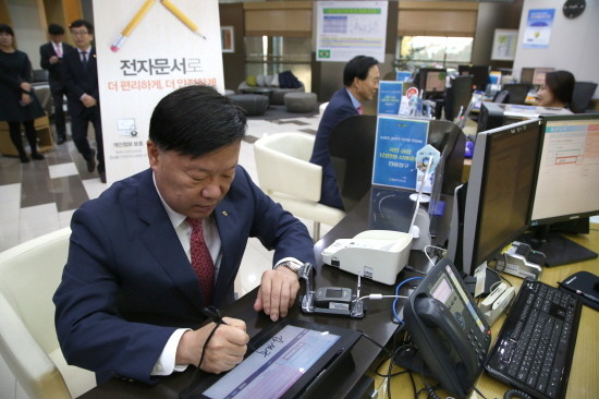 김원규 NH투자증권 사장이 영업점에서 전자문서를 이용해 현금을 출금하고 있다. (사진=NH투자증권)