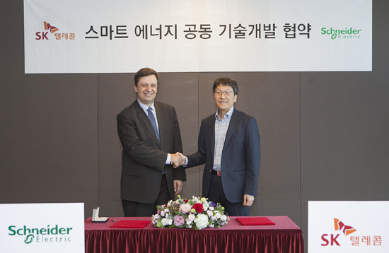 장홍성 SK텔레콤 솔루션기술원장(사진 오른쪽)과 뤽 르몽 슈나이더 일렉트릭 글로벌 부회장이 협약식 후 기념촬영을 하고 있다. (SK텔레콤 제공)