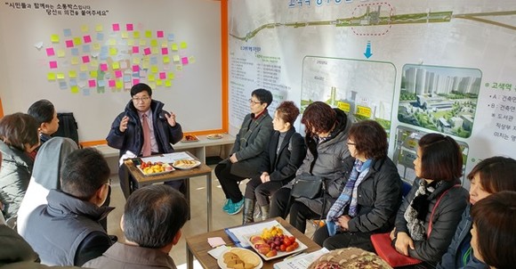 염태영 수원시장(정면 가운데)이 소통박스를 방문한 지역 주민들과 이야기 나누고 있다. 뒤편에 시민들이 의견을 적어 붙인 포스트잇이 보인다.(사진=수원시)