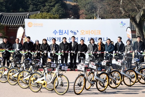 염태영 수원시장(왼쪽 7번째)과 키이스 진 오바이크 글로벌 COO(염 시장 오른쪽), 관계자들이 ‘스테이션 없는 무인대여 자전거’ 사업 개시 행사에서 테이프커팅을 하고 있다.(사진=수원시)