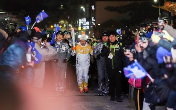 지난 5일 저녁 수원 화성행궁 광장에서 열린 ‘2018 평창 동계올림픽 성황봉송 축하행사’에서 성화주자(김훈동 대한적십자사 경기도지사 회장)가 도착해 행사장으로 들어오고 있다.(사진=경기도)