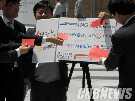 지난 2016년 소비자·시민사회단체가 생명보험사들의 자살보험금 지급을 촉구하며 레드카드를 붙이는 모습. (사진=CNB포토뱅크)