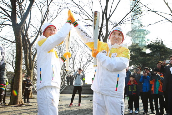15일 함영주 KEB하나은행장(사진 오른쪽)과 서홍석 삼천리기계 대표(사진 왼쪽)가 2018 평창동계올림픽 성화봉송 행사에 참여해 평창동계올림픽 성공을 기원하는 하이파이브를 하고 있는 모습. (사진=KEB하나은행)