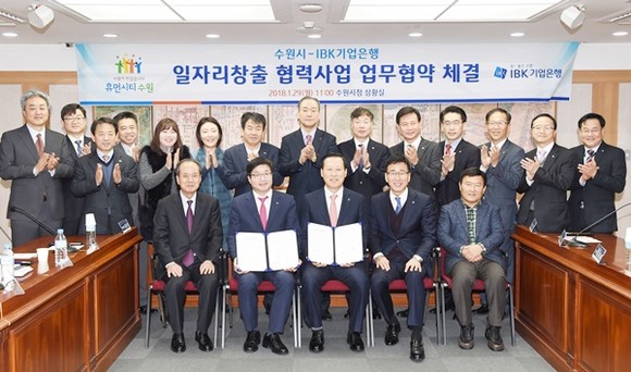 염태영 수원시장(앞줄 왼쪽 2번째)과 김도진 IBK기업은행장(염 시장 오른쪽), 관계자들이 업무협약 후 기념촬영을 하고 있다.(사진=수원시)
