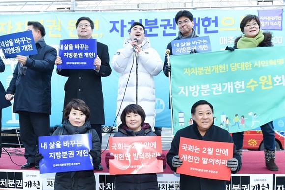 염태영 수원시장(뒷줄 왼쪽 2번째)과 김진관 수원시의회 의장(앞줄 오른쪽 1번째), 행사 참석자들이 지방분권 개헌을 촉구하는 패널을 들고 발언대에 서 있다.(사진=수원시)