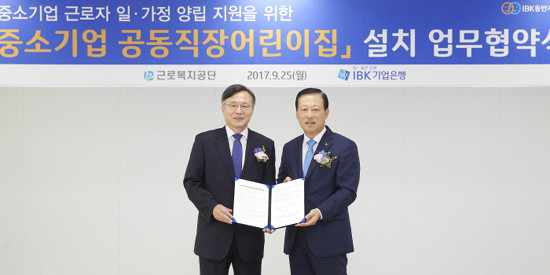 김도진 기업은행장(오른쪽)과 심경우 근로복지공단 이사장이 지난해 9월 서울 중구 IBK파이낸스타워에서 '중소기업 공동직장어린이집 설치' 업무협약식을 마치고 기념촬영 하는 모습.(사진=IBK기업은행)