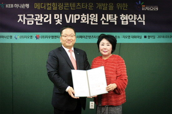 KEB하나은행은 5일 지우엠앤티·마스터페이콘텐츠타운사업단과 내외국인 의료관광 및 바이오 융합 사업의 ‘신탁자금관리’를 위한 전략적 업무협약을 체결했다. 협약식에서 이호성 KEB하나은행 중앙영업그룹 전무(사진 왼쪽)와 지우엠앤티 조선혜 회장(사진 오른쪽)이 협약식 후 기념촬영을 하고 있다. (사진=KEB하나은행)