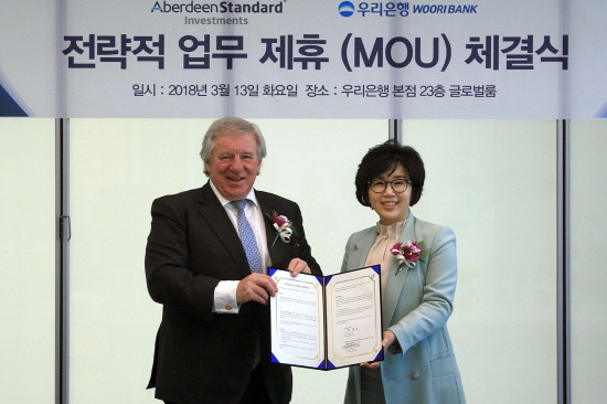 우리은행은 지난 13일 서울 중구 본점에서 ‘우리은행-英 애버딘 스탠다드 인베스트먼츠와 전략적 업무제휴 협약’을 체결했다. 정종숙 우리은행 WM그룹장(사진 오른쪽)이 마틴 길버트 애버딘 스탠다드 인베스트먼츠 CEO와 기념촬영을 하고 있다. (사진=우리은행)