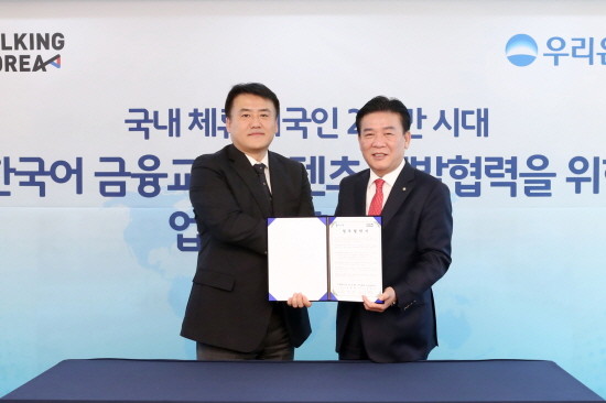 우리은행이 지난 16일 서울 중구 본점에서 ‘우리은행-토킹코리아, 한국어 금융·교육 융합 서비스 개발을 위한 업무제휴 협약’을 체결했다. 김영배 우리은행 외환그룹 그룹장(사진 오른쪽)이 김형국 토킹코리아 대표와 기념촬영을 하고 있다. (사진=우리은행)