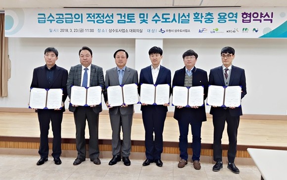 김교선 수원시 상수도사업소장(왼쪽 3번째)과 5개 개발사업 시행사 관계자들이 협약 후 기념촬영을 하고 있다.(사진=수원시)