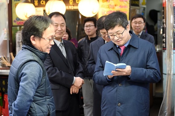 염태영 수원시장이 구매탄시장 상인으로부터 건의사항을 들으며 메모하고 있다.(사진=수원시)
