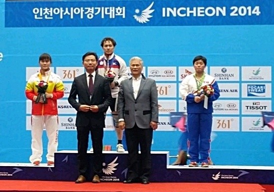 고양시역도연맹 장은환 회장(앞줄 왼쪽)이 2014인천아시안경기대회에서 북한선수들에게 시상한 장면(사진= 고양시역도연맹)