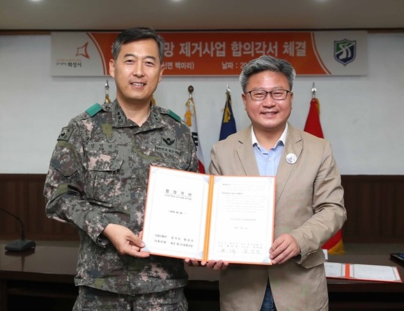 채인석 화성시장(오른쪽)과 김인건 51사단장이 26일 백미리 해안 철조망 제거를 위한 합의각서를 체결했다.(사진=화성시)