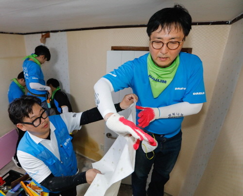 대림산업 박상신 대표(우측 첫번째)가 직원들과 함께 도배작업을 하고 있다. (사진=대림산업)