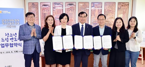 송영완 수원시 문화체육교육국장(가운데)과 삼성전자 수원사회봉사단 김석은 부장(송 국장 오른쪽), 류주선 수원청소년육성재단 희망등대센터장(송 국장 왼쪽), 관계자들이 업무협약 후 기념촬영을 하고 있다.(사진=수원시)