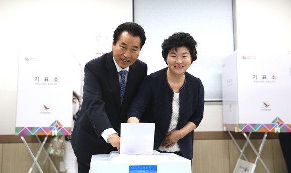 백군기 용인시장후보가 손숙자 여사와 함께 첫 번째 투표자로 투표를 하고 있다.