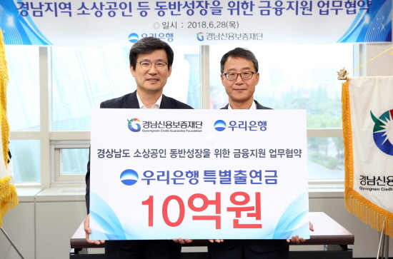 이창재 우리은행 부행장(사진 왼쪽)이 김민수 경남신용보증재단 이사장 대행과 기념촬영을 하고 있다. (사진=우리은행)