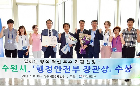 이택용 수원시 일자리경제국장(왼쪽 5번째)과 수원시 공직자들이 기념촬영을 하고 있다.(사진=수원시)