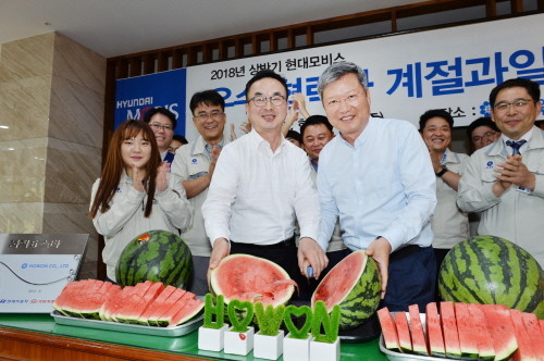 김대곤 현대모비스 구매지원담당 상무(가운데 왼쪽)와 양진석 ㈜호원 대표이사(가운데 오른쪽)가 수박을 나누며 상생 결의를 다지는 모습. (사진=현대모비스)