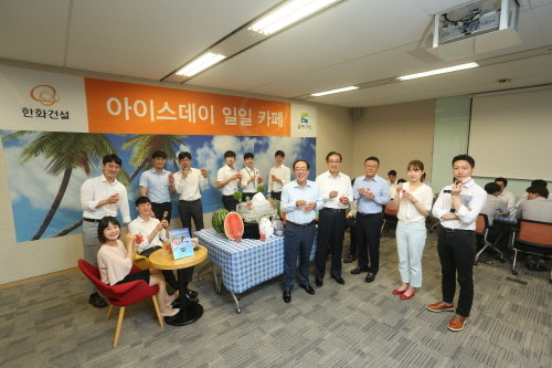 최광호 대표이사(앞줄 오른쪽 다섯번째)와 한화건설 임직원들이 아이스데이 일일카페에서 아이스크림과 수박을 나누며 기념사진을 촬영하고 있다. (사진=한화건설)