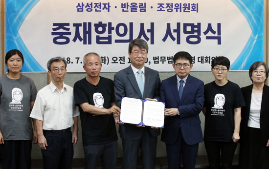 지난 7월 서울 서대문구 법무법인 지평에서 열린 '삼성전자-반올림(반도체 노동자의 건강과 인권 지킴이)-조정위 3자간 제2차 조정재개 및 중재방식 합의서명식'에서 중재합의서를 들고 기념촬영하는 (왼쪽 세번째부터)반올림 황상기 대표, 김지형 조정위원장, 김선식 삼성전자 전무와 조정위원 및 관계자들. (사진=연합뉴스 제공)
