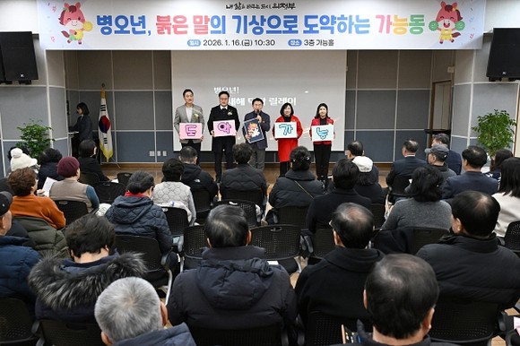 의정부시 가능동주민센터 3층 가능홀에서 주민과 내빈이 참석한 가운데 2026년 주요업무보고회가 열리고, 무대에서 사업 계획을 설명하는 모습