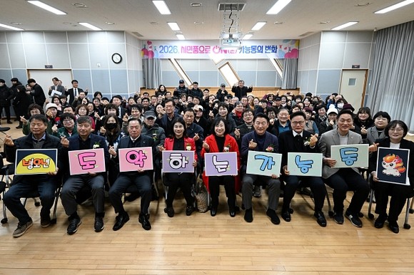 의정부시 가능동주민센터 3층 가능홀에서 주민과 내빈이 참석한 가운데 2026년 주요업무보고회가 열리고, 기념촬영을 하는 모습