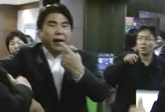 한나라당 김성회 의원이 민주당 강기정 의원을 정면 가격한 뒤 자신도 맞았다는 듯한 제스처를 하는 사이 옆의 남자가 놀란 표정을 짓고 있다. (